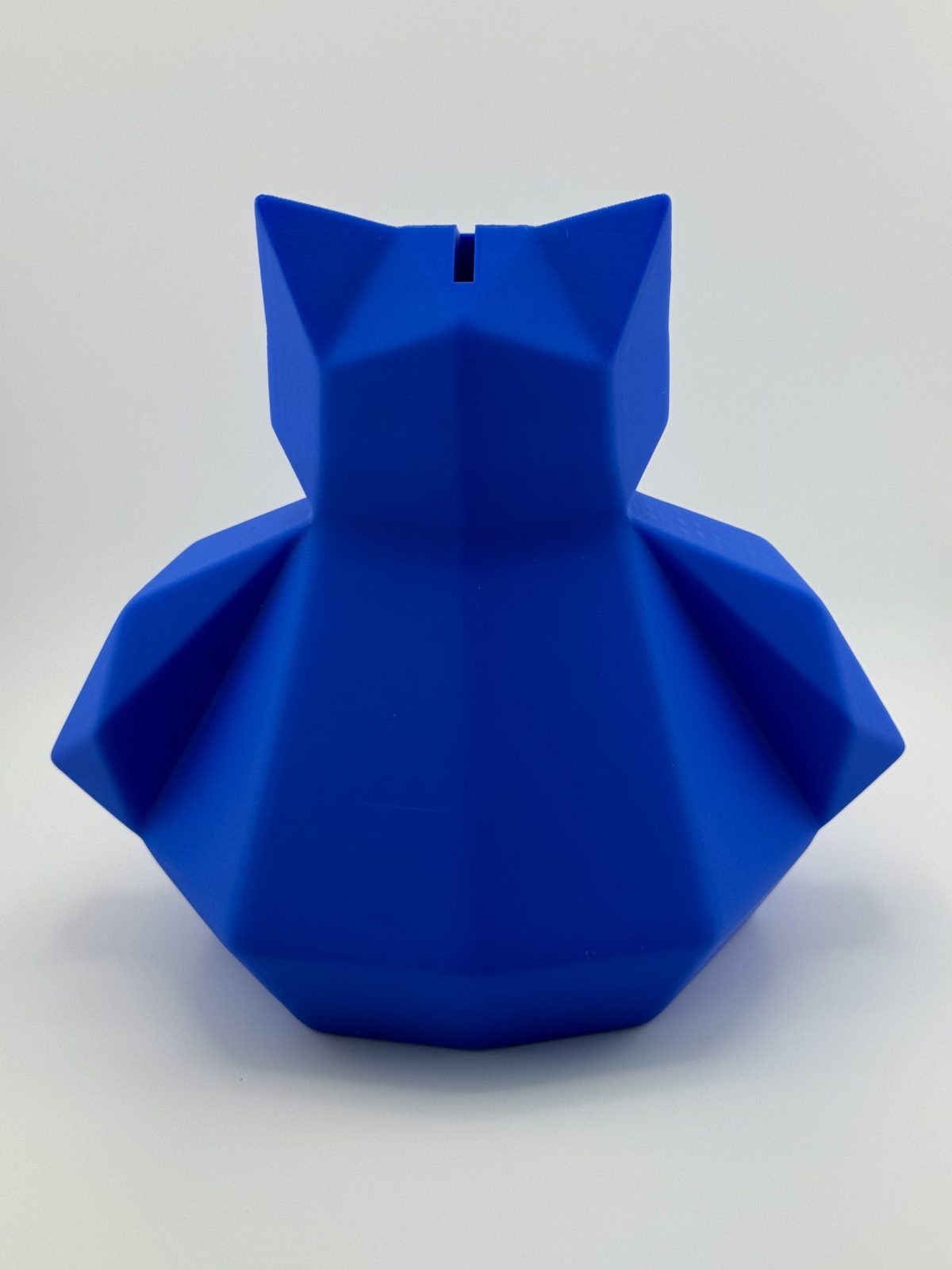 Deep blue low-poly 3D-printed Snorlax coin bank, 18 cm tall, designed with a coin slot and a twist cap at the bottom, ideal for fans of the sleepy Pokémon.