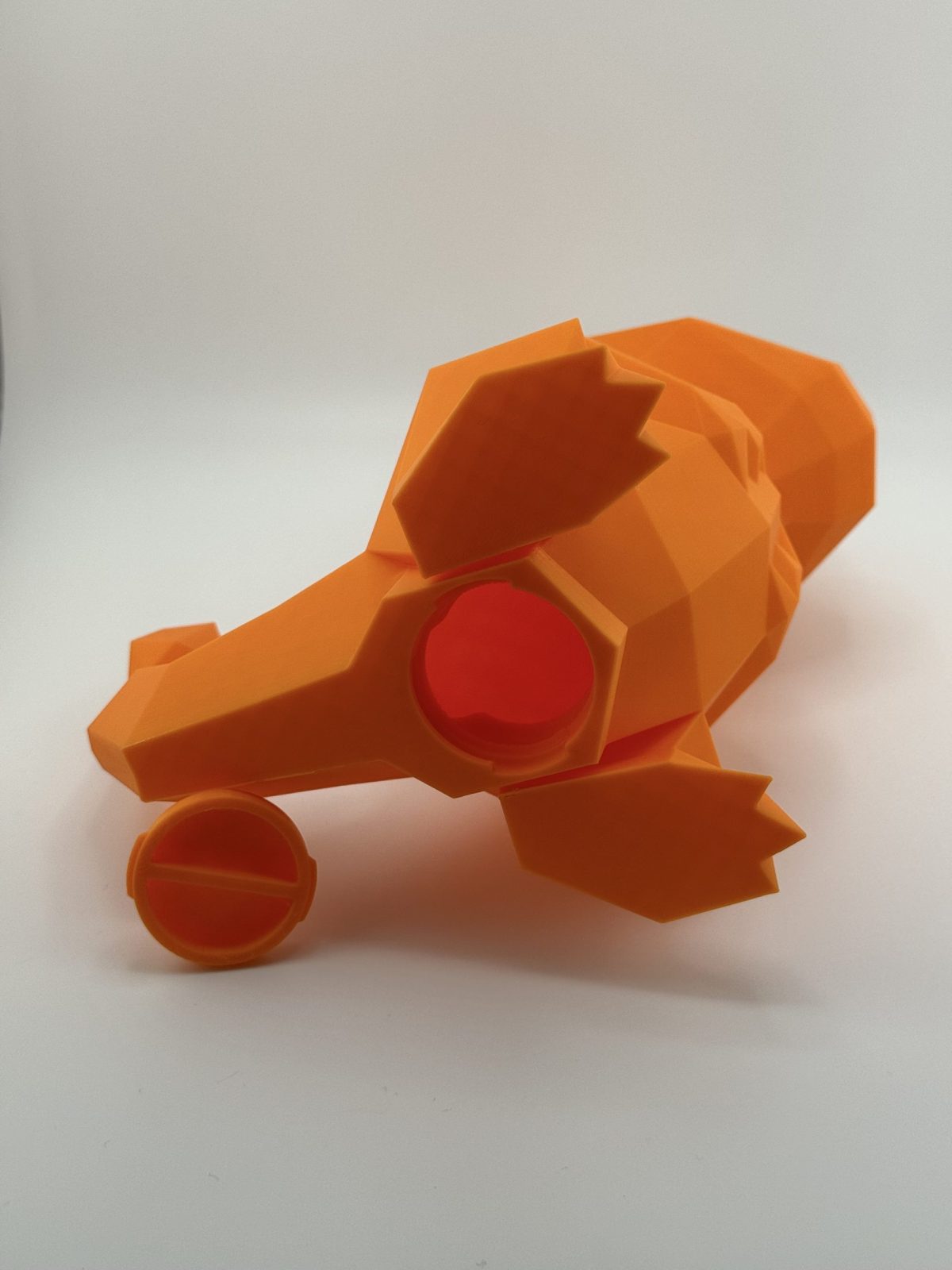 Fiery orange low-poly 3D-printed Charmander coin bank, 22.5 cm tall with a coin slot, designed to resemble the beloved Pokémon.