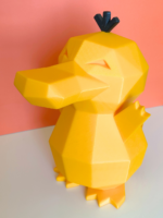 Low-poly 3D-printed Psyduck coin bank in vibrant yellow color, standing upright with a coin slot on the back